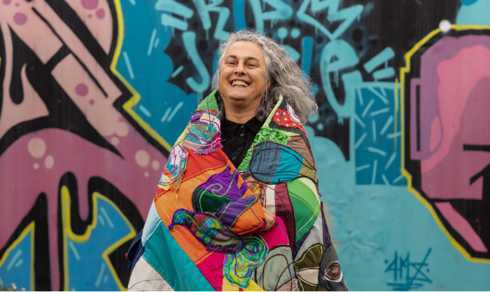 Image if women smiling infornt of graffiti art 